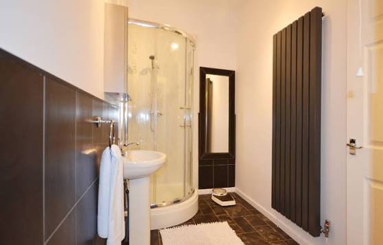 Bathroom with corner shower and pedestal sink